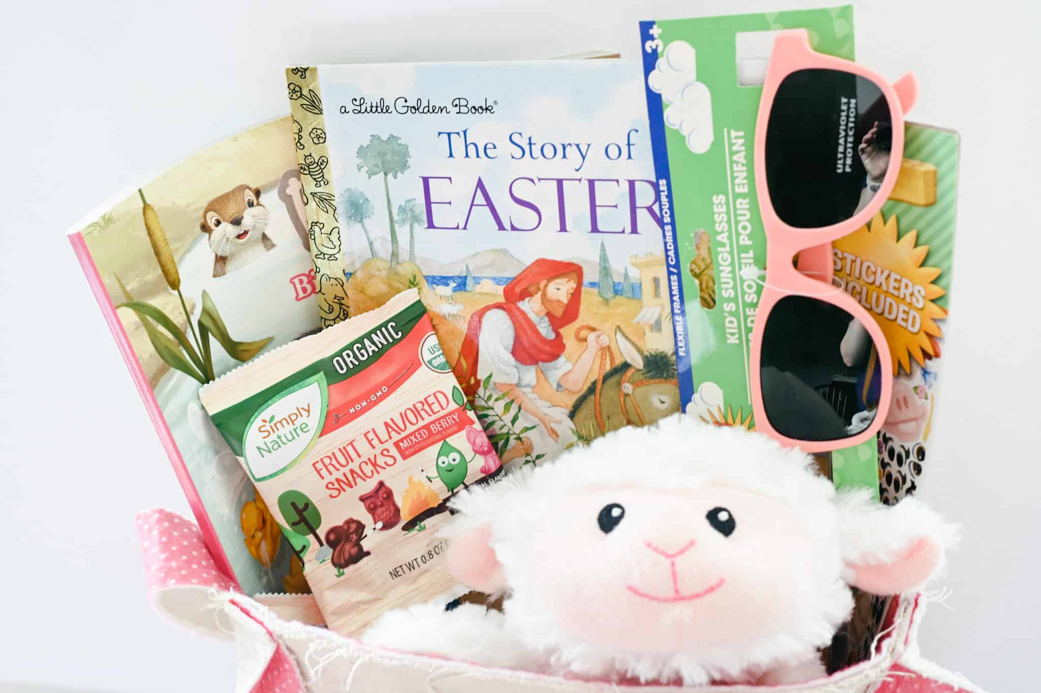 cloth easter basket with sunglasses, organic fruit snacks, easter books, color and activity books