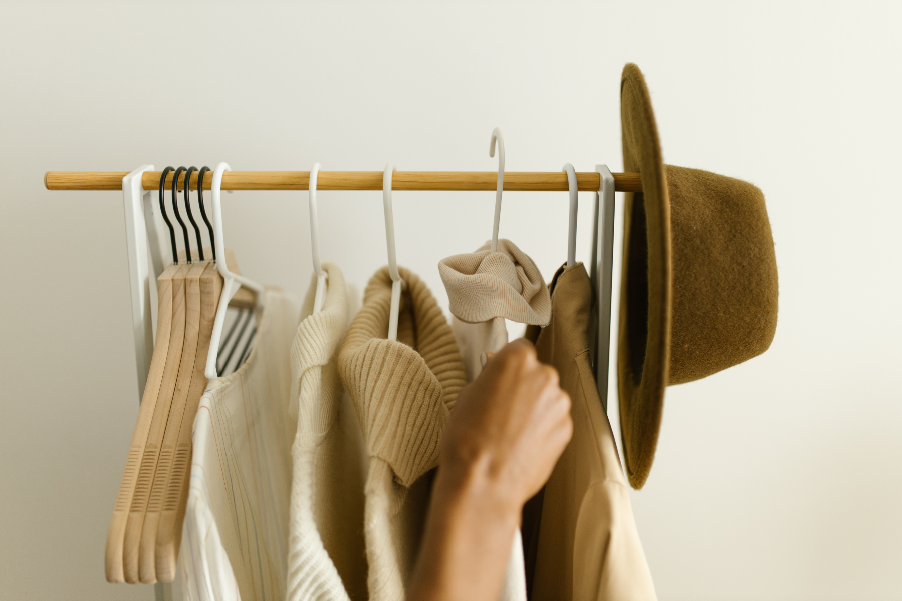 clothes hanging on clothes rack with hat