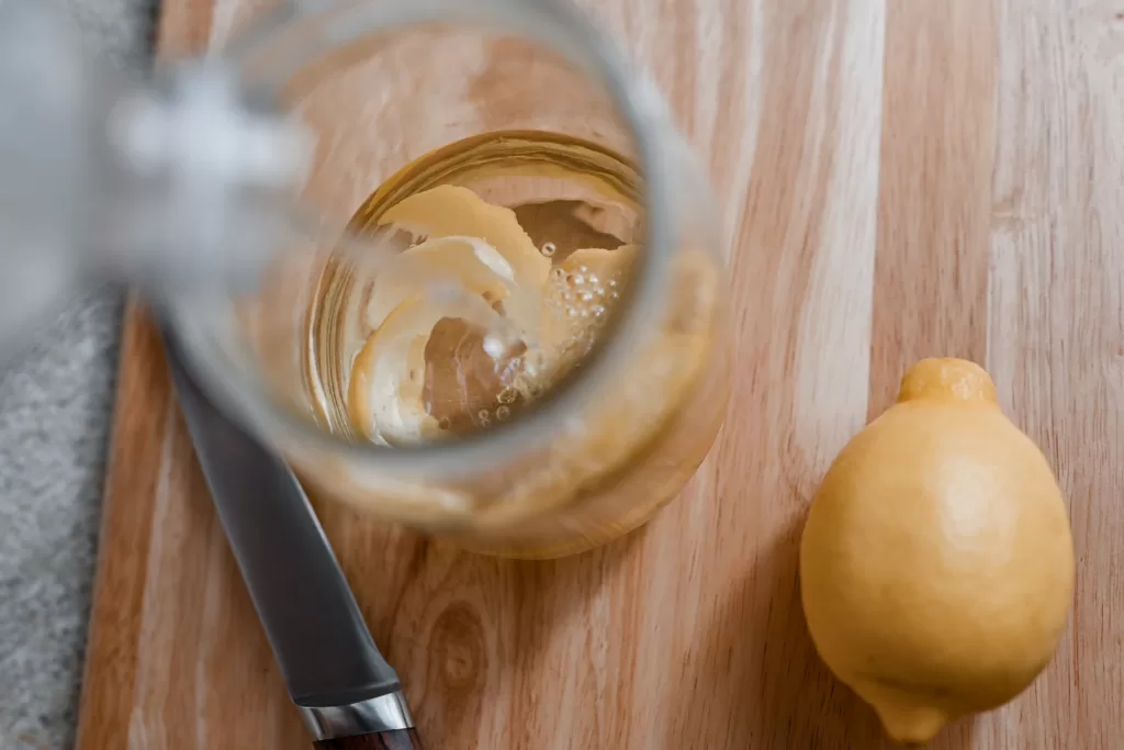 pouring vinegar over lemon peels to make homemade all-purpose cleaner
